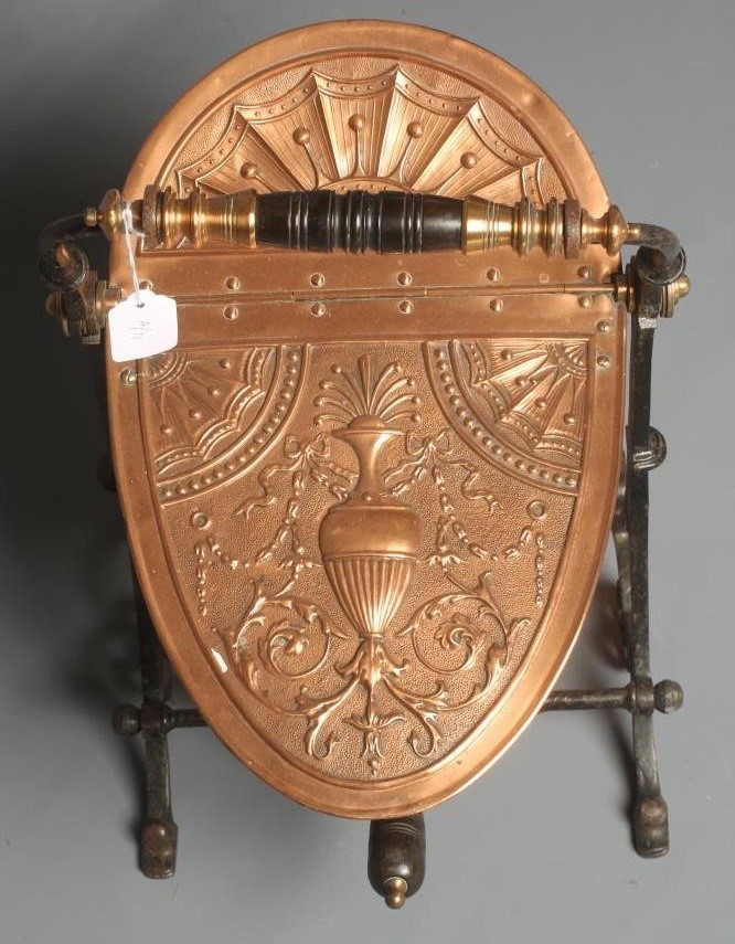 A VICTORIAN COPPER COAL SCUTTLE of helmet form raised on an open scroll work Image