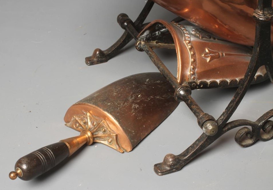 A VICTORIAN COPPER COAL SCUTTLE of helmet form raised on an open scroll work Image