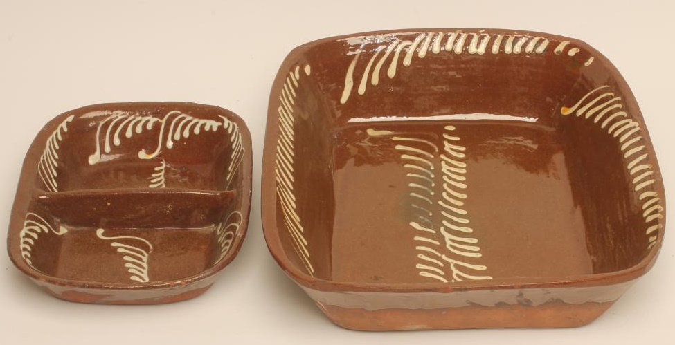 A SLIPWARE BAKING DISH of plain rounded oblong form with pale cream slip feathered border Image