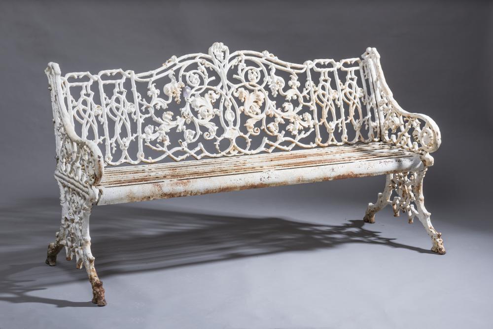 A VICTORIAN CAST IRON GARDEN SEAT in "Rustic" pattern with slatted cast iron garden seat Image