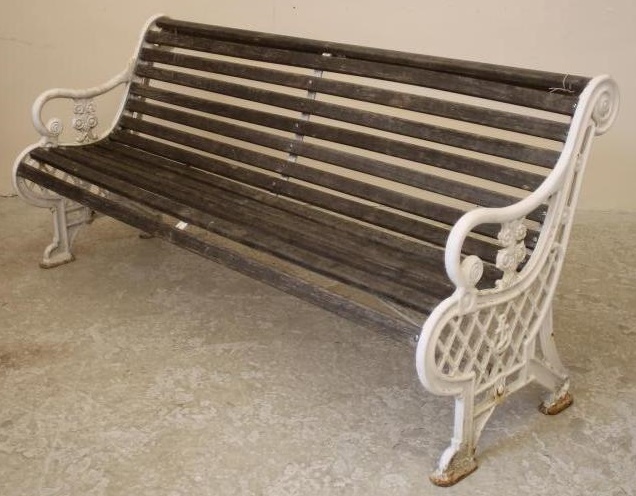 A VICTORIAN CAST IRON GARDEN BENCH with slatted wood seat and back Image