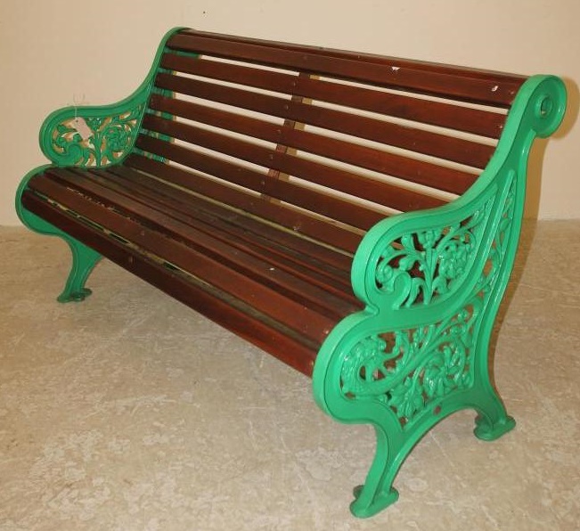 A VICTORIAN CAST IRON GARDEN BENCH with mahogany slatted seat and back Image