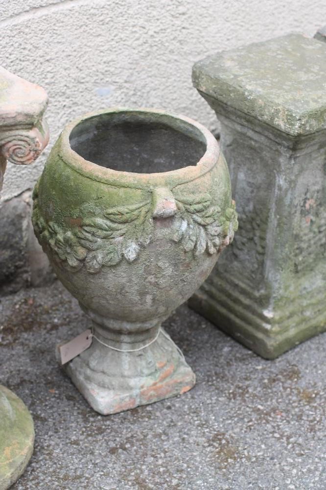 A VICTORIAN TERRACOTTA URN of ovoid form with floral swags suspended from lug handles Image