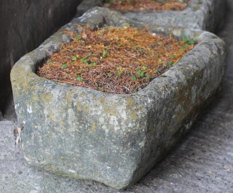 A SANDSTONE TROUGH of rough hewn rounded oblong tapering form Image