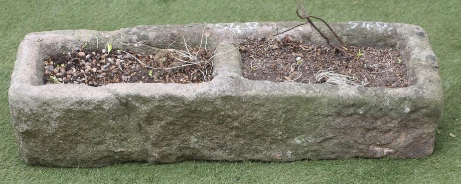 A SANDSTONE TROUGH of rough hewn oblong form with central division Image