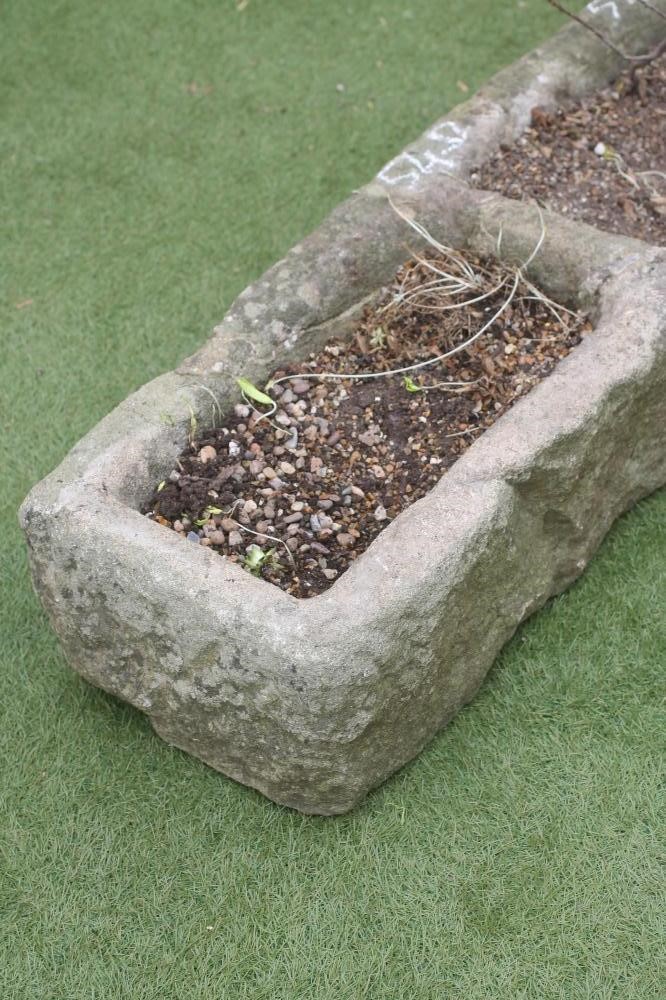 A SANDSTONE TROUGH of rough hewn oblong form with central division Image