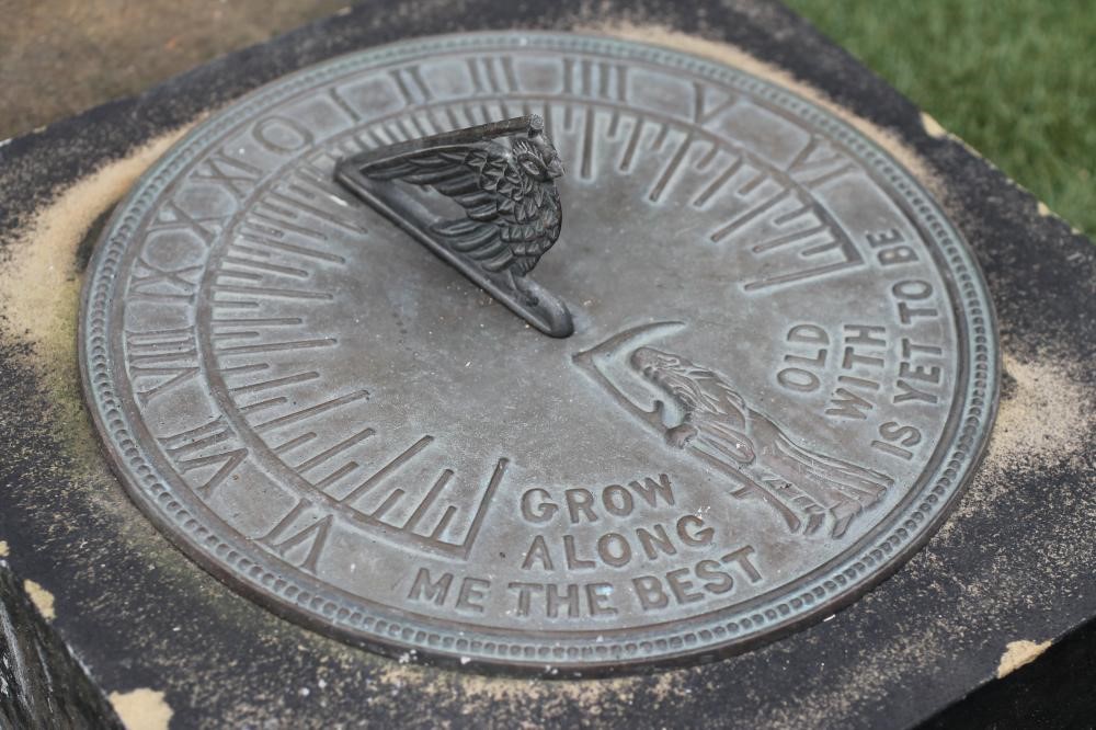 A SANDSTONE BLOCK of square form with modern bronzed sundial Image