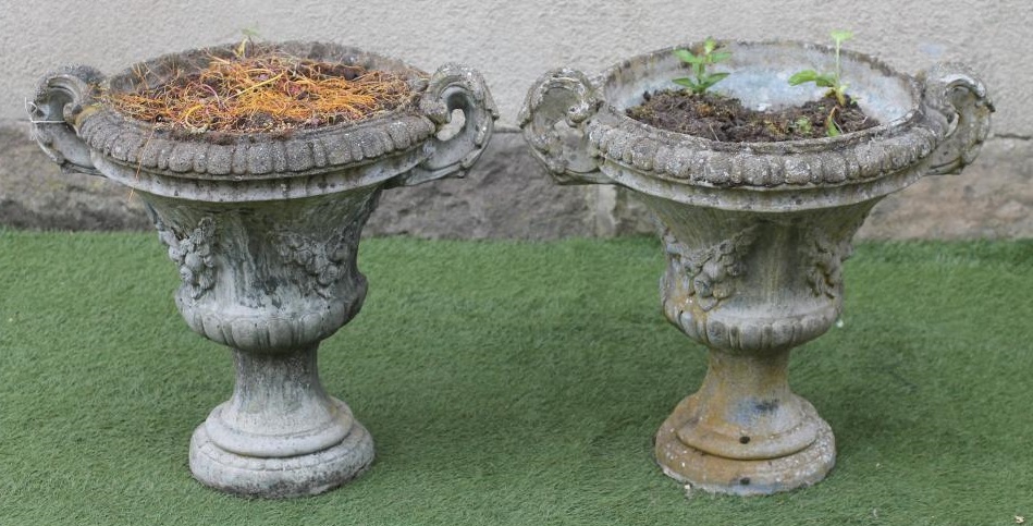 A PAIR OF COMPOSITION STONE URNS of half fluted campana form with fruit swags and acanthus sheathed Image