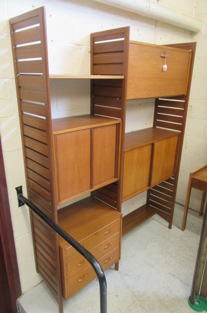 A STAPLES TEAK LADDERAX ROOM UNIT comprising three wooden ladders supporting a cupboard with sliding Image
