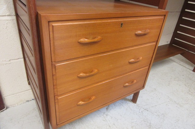 A STAPLES TEAK LADDERAX ROOM UNIT comprising three wooden ladders supporting a cupboard with sliding Image