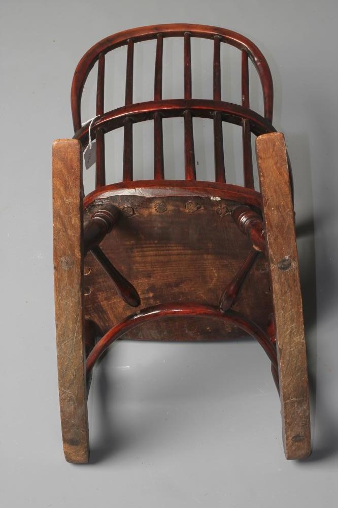 A CHILD'S YEW WOOD WINDSOR ROCKING CHAIR of low hooped stick back form Image