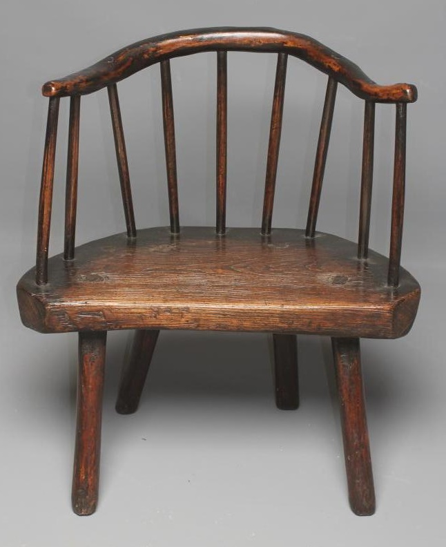 A PRIMITIVE ASH AND ELM STICK BACK ELBOW CHAIR with arched rustic top rail Image