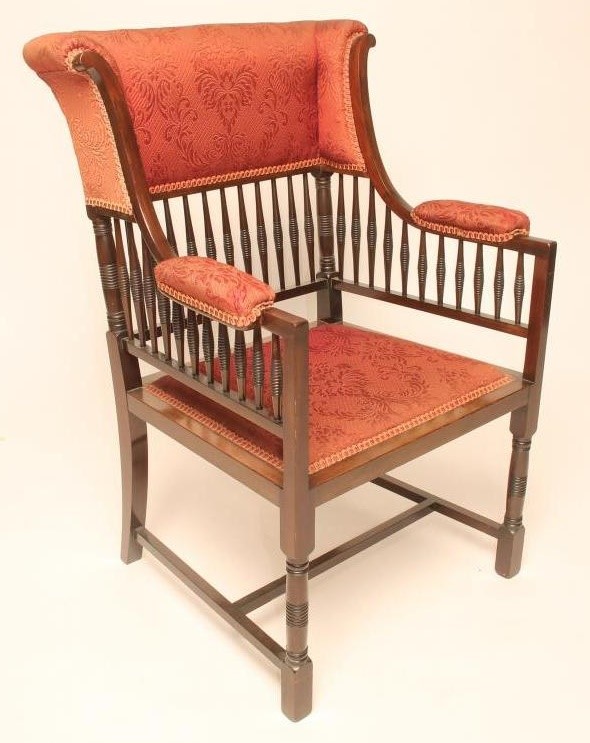 AN AESTHETIC MAHOGANY FRAMED WING ELBOW CHAIR upholstered in a red weave Image
