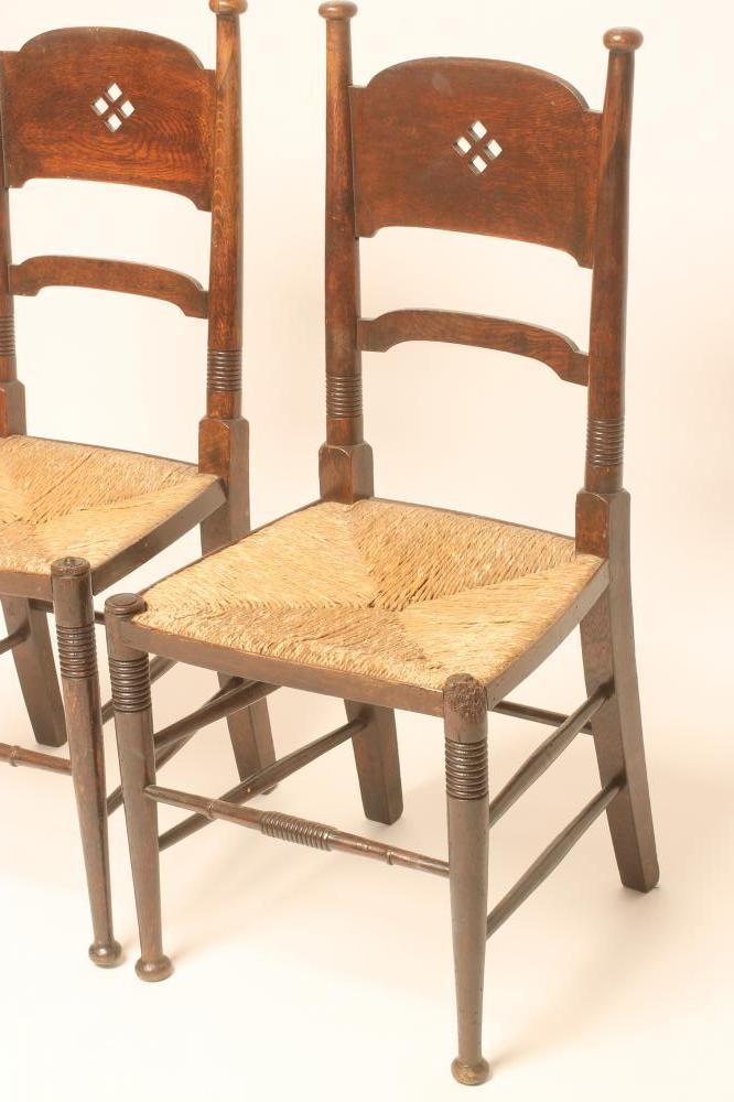 A MATCHED PAIR OF WILLIAM BIRCH ARTS AND CRAFTS OAK CHAIRS Image
