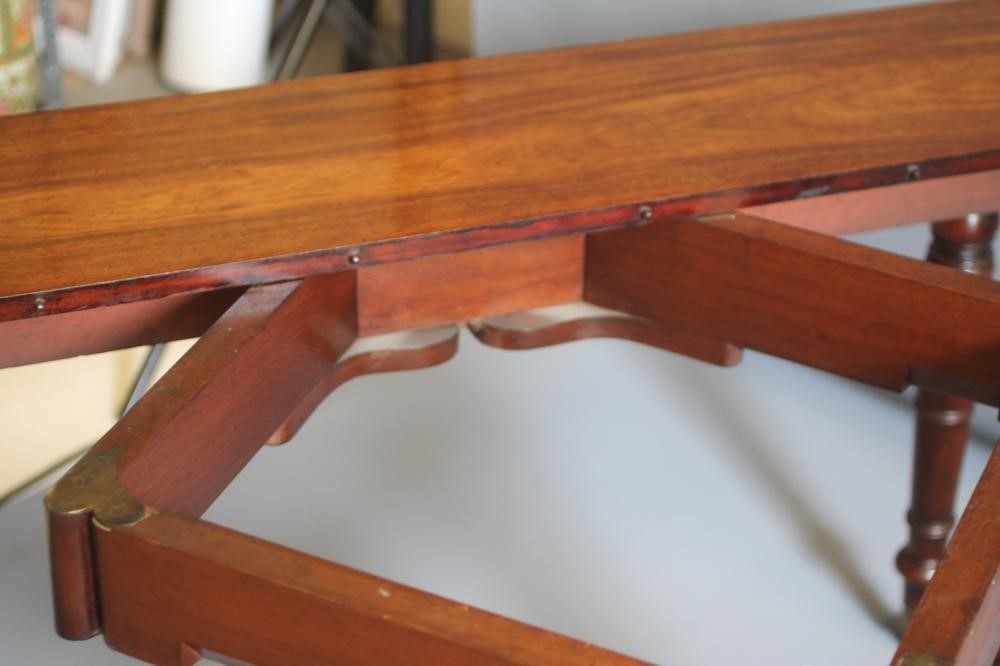 A FINE QUALITY REGENCY MAHOGANY EXTENDING DINING TABLE of rounded oblong form with ebony stringing Image