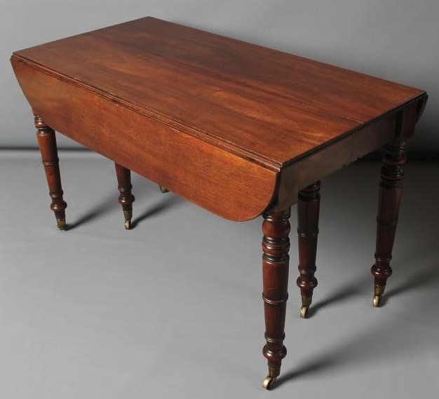 A FINE QUALITY REGENCY MAHOGANY EXTENDING DINING TABLE of rounded oblong form with ebony stringing Image