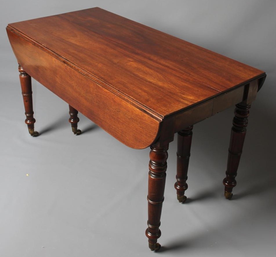 A FINE QUALITY REGENCY MAHOGANY EXTENDING DINING TABLE of rounded oblong form with ebony stringing Image