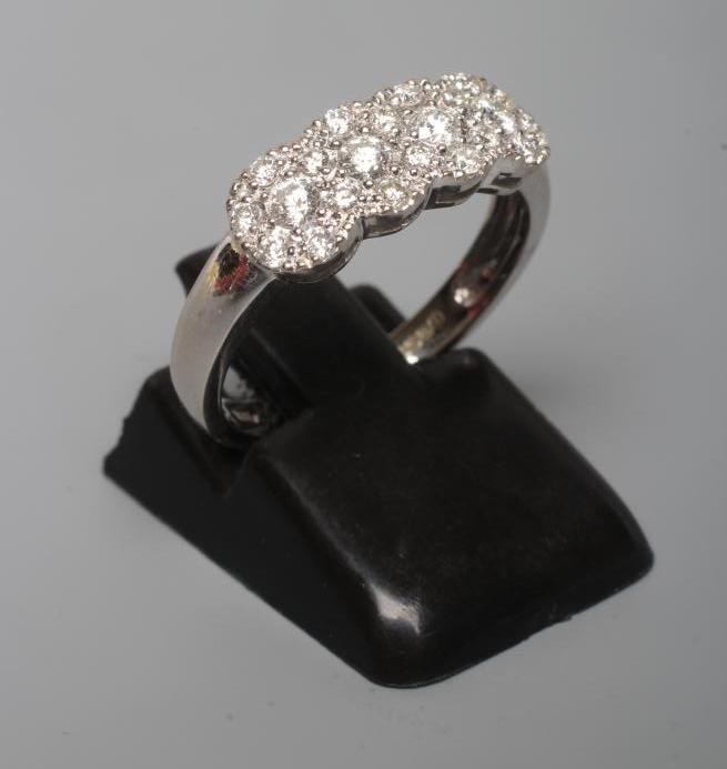 A DIAMOND RING, thr four small clusters each point with seven stone to a plain 18ct white gold Image
