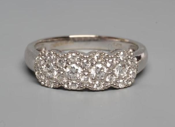 A DIAMOND RING, thr four small clusters each point with seven stone to a plain 18ct white gold Image