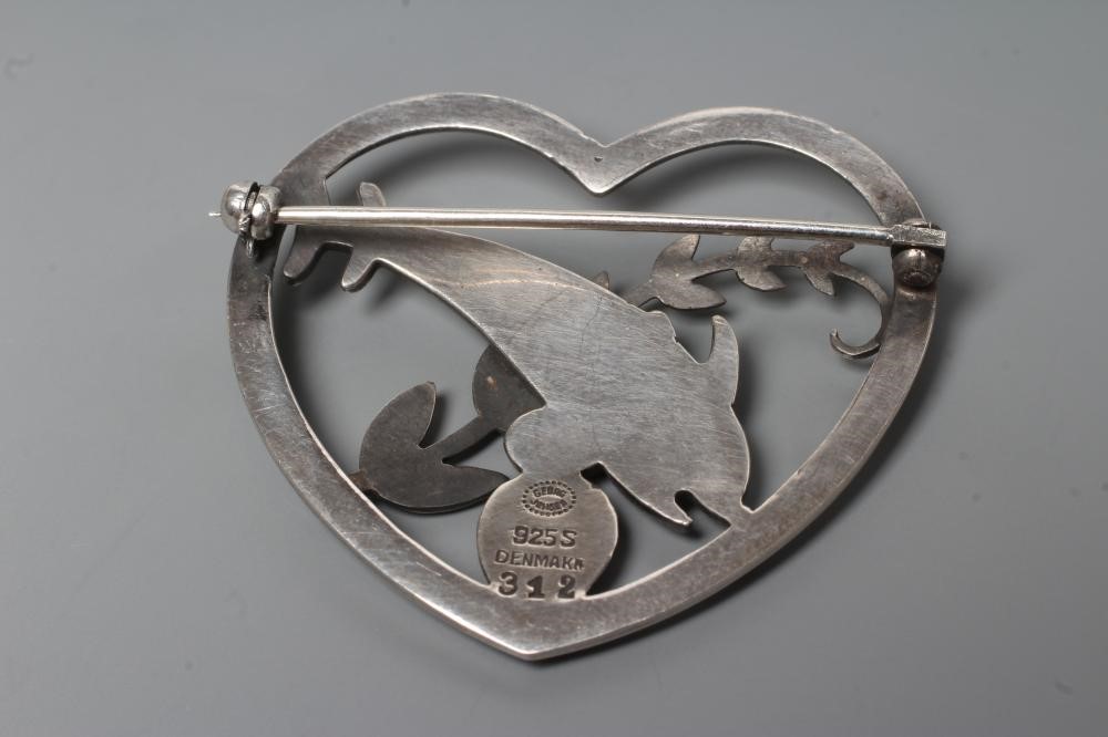 A GEORG JENSEN SILVER HEART BROOCH designed by Arno Malinowski, cast as two dolphins swimming amidst Image