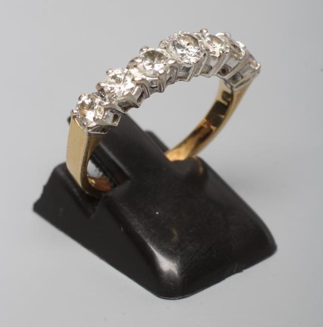 A SEVEN STONE DIAMOND HALF HOOP ETERNITY RING, the round brilliant cut stones claw set to a plain Image