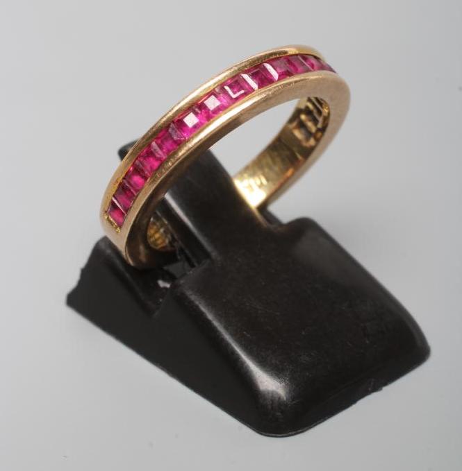 A RUBY HALF HOOP ETERNITY RING, the eighteen square cut stones channel set to a plain shank stamped Image
