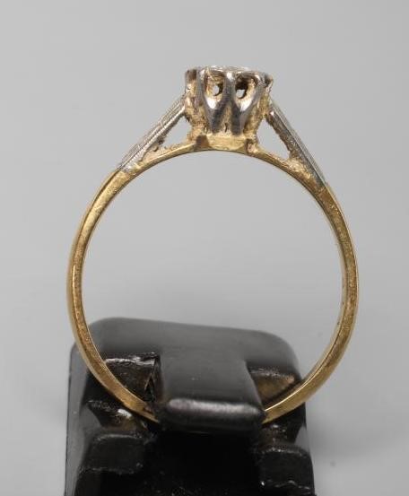 A SOLITAIRE DIAMOND RING, the brilliant cut stone illusion set to geometric engraved white shoulders Image