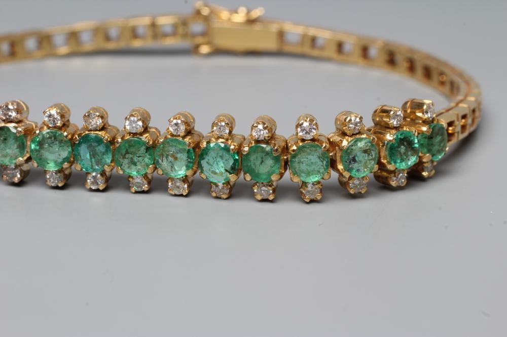 AN EMERALD AND DIAMOND BRACELET, the sixteen circular facet cut emeralds each flanked by two small Image