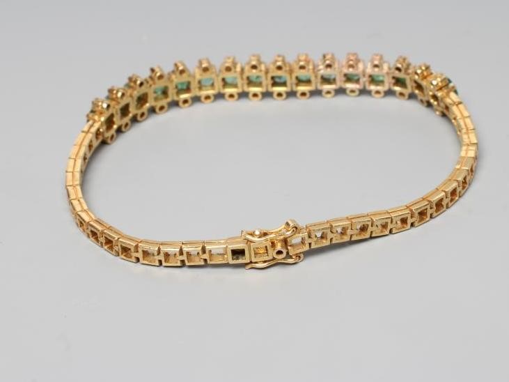 AN EMERALD AND DIAMOND BRACELET, the sixteen circular facet cut emeralds each flanked by two small Image
