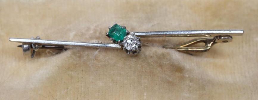 AN EMERALD AND DIAMOND BAR BROOCH, the circular facet cut stones claw set to an asymetrical knife Image
