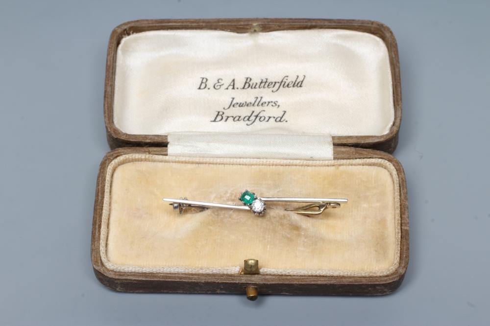 AN EMERALD AND DIAMOND BAR BROOCH, the circular facet cut stones claw set to an asymetrical knife Image