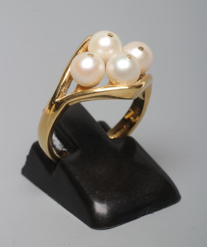 A PEARL DRESS RING, the four cultured pearls "show peg" set to an open lozenge panel and plain 18ct Image