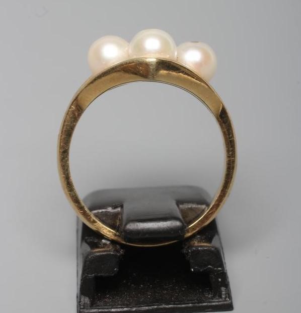 A PEARL DRESS RING, the four cultured pearls "show peg" set to an open lozenge panel and plain 18ct Image