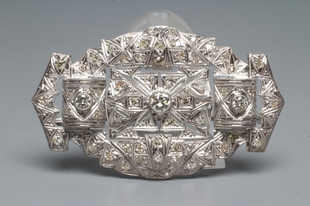 A DIAMOND OVAL OPEN PANEL BROOCH, the central open back collet set stone of approximately 0.35cts Image