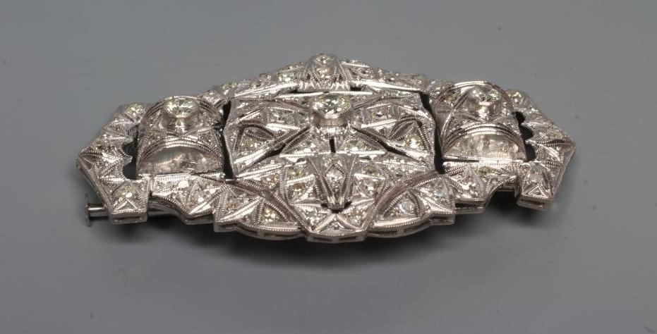 A DIAMOND OVAL OPEN PANEL BROOCH, the central open back collet set stone of approximately 0.35cts Image