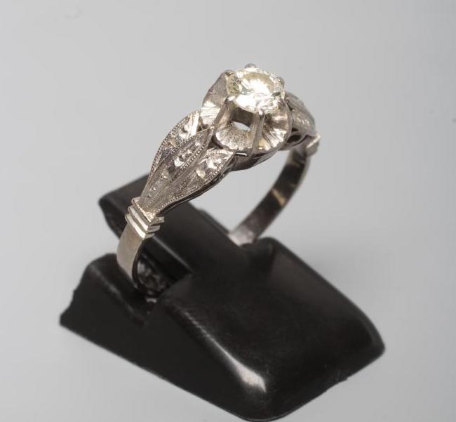 A SOLITAIRE DIAMOND RING, the brilliant cut stone of approximately 0.5cts claw set to a flower panel Image