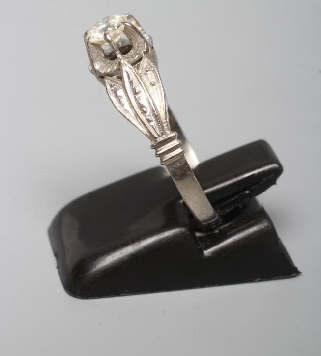 A SOLITAIRE DIAMOND RING, the brilliant cut stone of approximately 0.5cts claw set to a flower panel Image