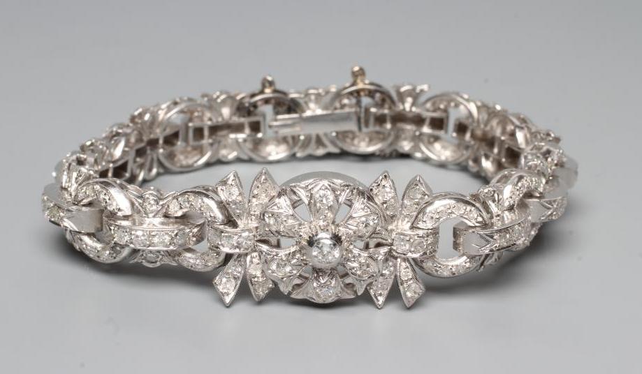 A DIAMOND BRACELET, the central cluster with bow shoulders and open circular links and invisible Image