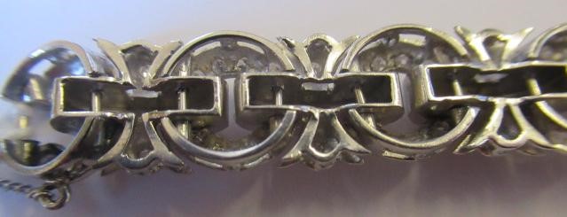 A DIAMOND BRACELET, the central cluster with bow shoulders and open circular links and invisible Image