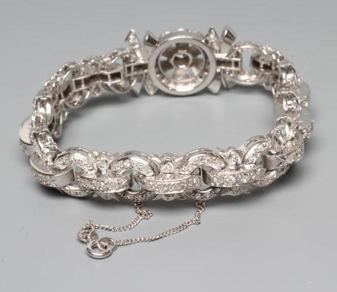 A DIAMOND BRACELET, the central cluster with bow shoulders and open circular links and invisible Image