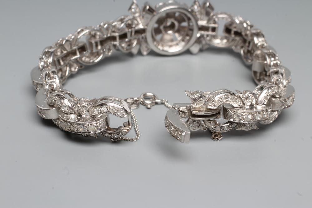 A DIAMOND BRACELET, the central cluster with bow shoulders and open circular links and invisible Image