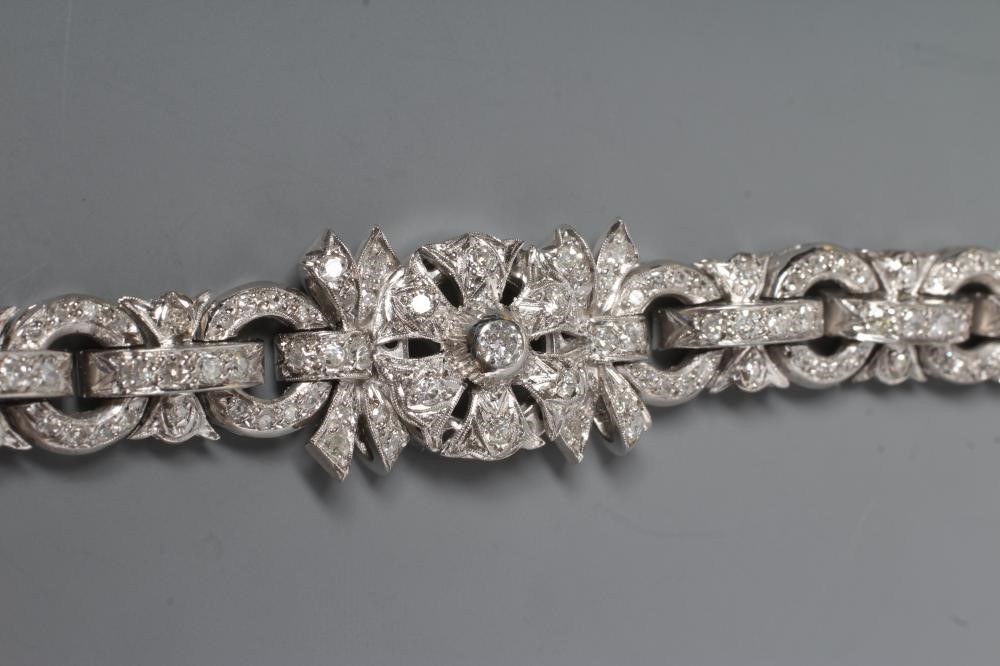 A DIAMOND BRACELET, the central cluster with bow shoulders and open circular links and invisible Image
