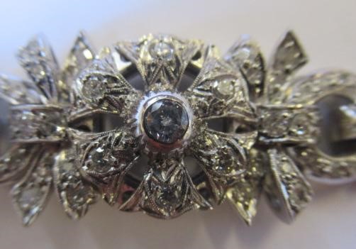 A DIAMOND BRACELET, the central cluster with bow shoulders and open circular links and invisible Image