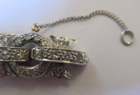 A DIAMOND BRACELET, the central cluster with bow shoulders and open circular links and invisible Image
