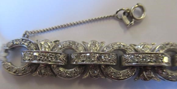 A DIAMOND BRACELET, the central cluster with bow shoulders and open circular links and invisible Image
