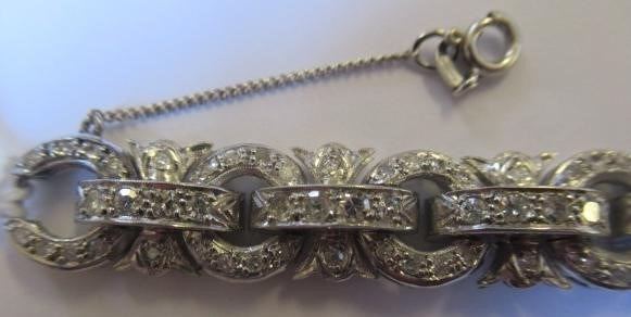 A DIAMOND BRACELET, the central cluster with bow shoulders and open circular links and invisible Image