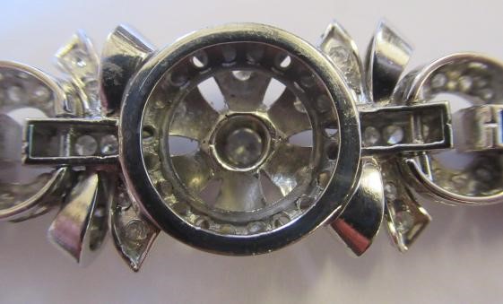 A DIAMOND BRACELET, the central cluster with bow shoulders and open circular links and invisible Image