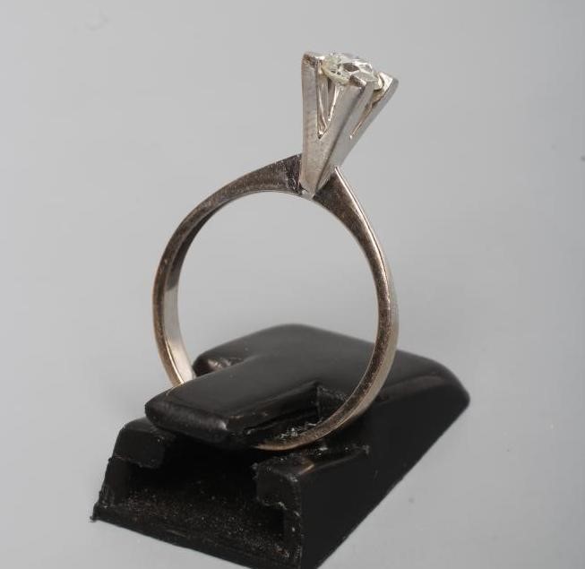 A SOLITAIRE DIAMOND RING, the round brilliant cut stone of approximately 0.30cts claw set to a plain Image