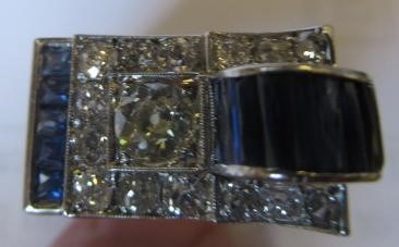 AN ART DECO STYLE SAPPHIRE AND DIAMOND "BUCKLE" COCKTAIL RING Image