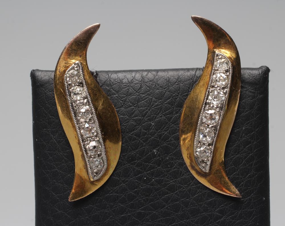 A PAIR OF DIAMOND STUD EARRINGS, the stylised "S" panels pave set with a line of six mixed cut Image